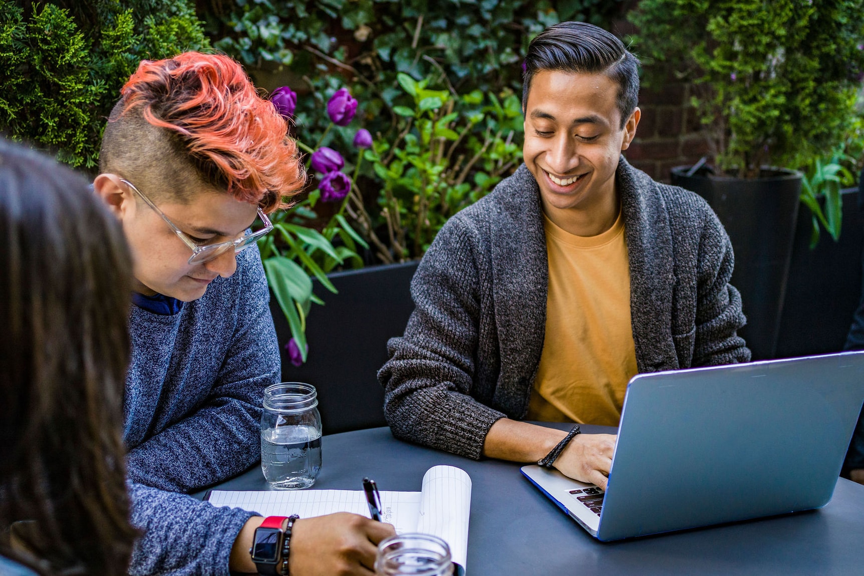 A group of case managers collaborating at a table, with a laptop and papers in front of them.