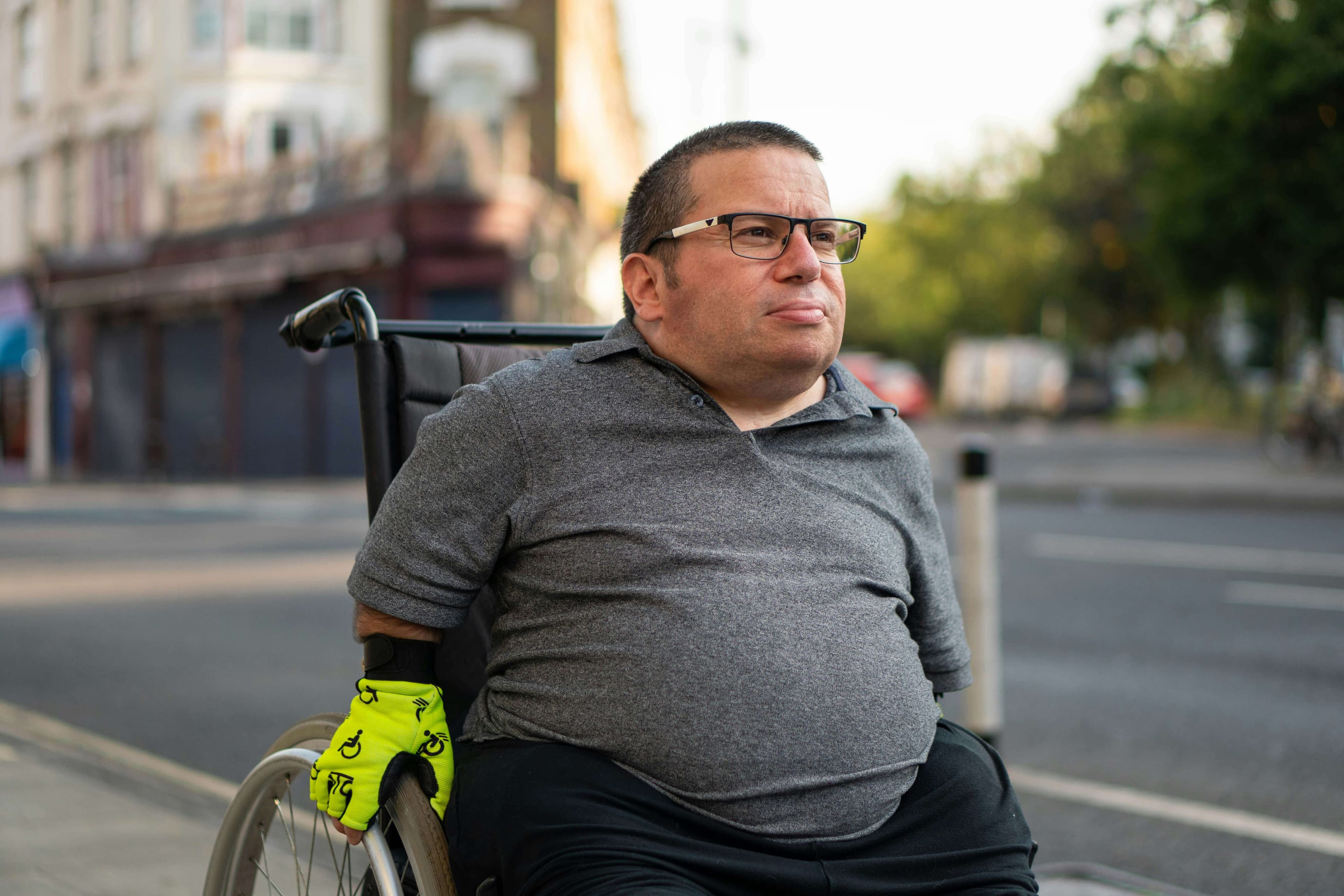 A middle-aged man using a wheelchair and looking into the distance