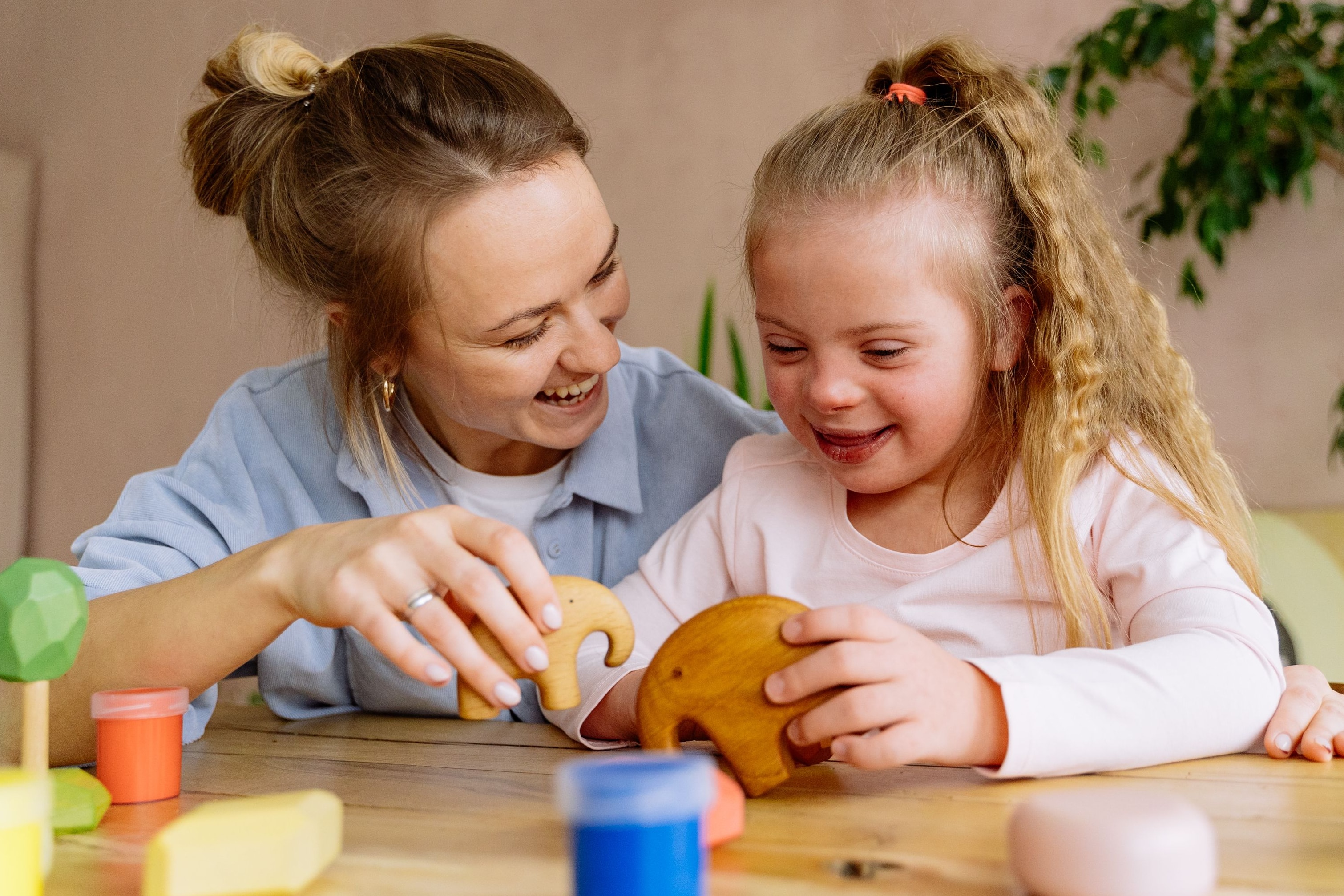 A therapist finger painting with a young child with disabilities.